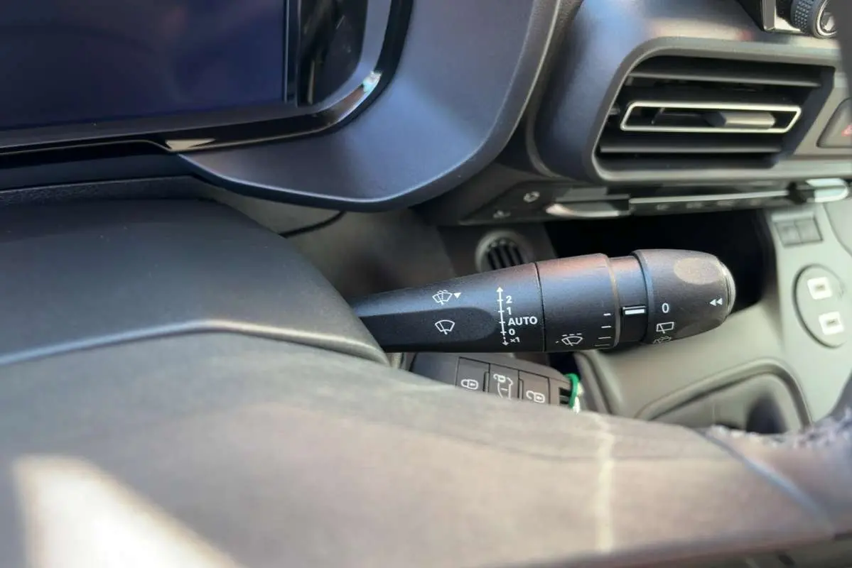 Gros plan sur la commande des essuie-glaces côté gauche du tableau de bord du Citroën Berlingo 2026 intérieur noir.