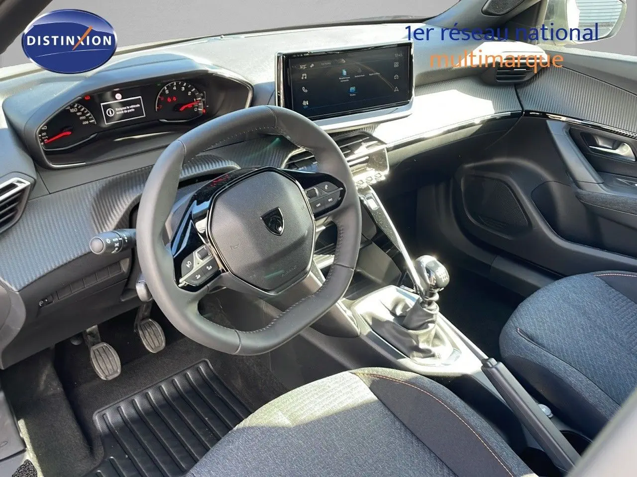 Intérieur de la Peugeot 2008 2025 avec tableau de bord moderne, volant compact et levier de vitesse manuel visible côté conducteur.