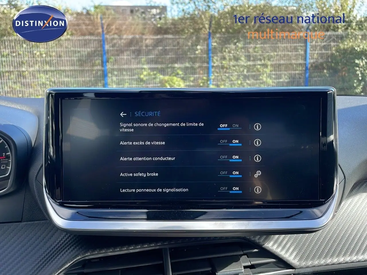 Écran tactile central affichant les réglages de sécurité du Peugeot 2008 blanc, vue intérieure frontale.