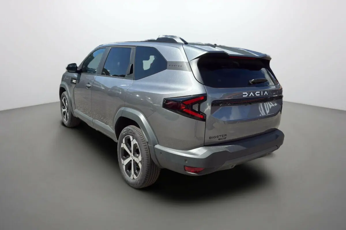 Vue 3/4 arrière droit du SUV Dacia Bigster gris schiste avec feux arrière en forme de flèche et jantes alu 18 pouces.