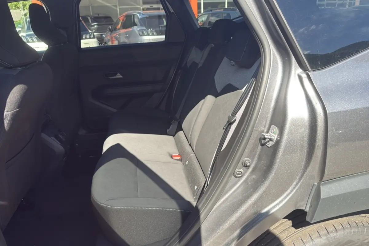 Vue côté gauche arrière du Dacia Bigster gris schiste, mettant en valeur la banquette arrière et l'ouverture de porte.