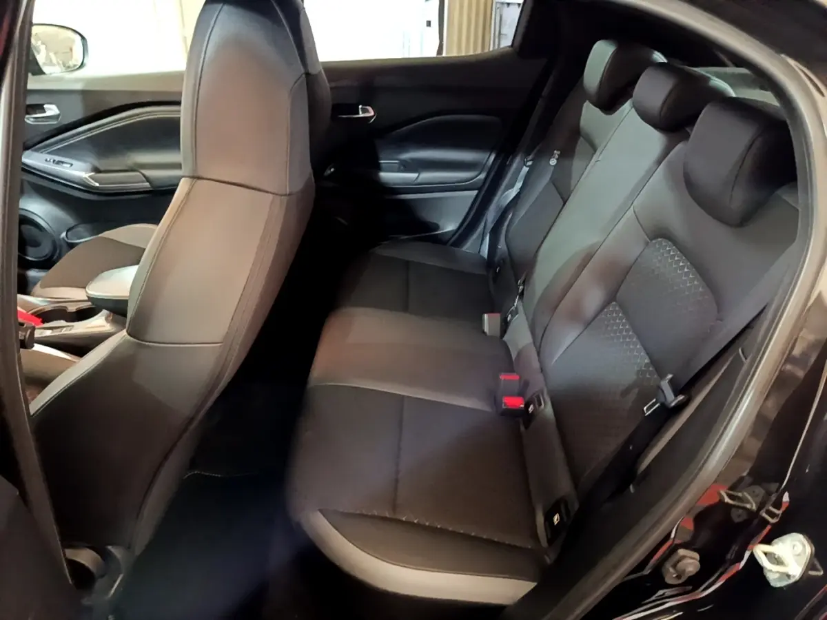 Vue intérieure côté droit montrant la banquette arrière noire du Nissan Juke Hybrid 143 Business+ 2022.