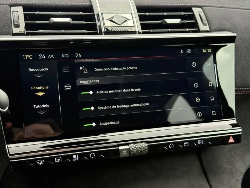 Écran tactile central du DS7 E-TENSE 225ch 2024 affichant les aides à la conduite, dans un intérieur noir avec finitions chromées.