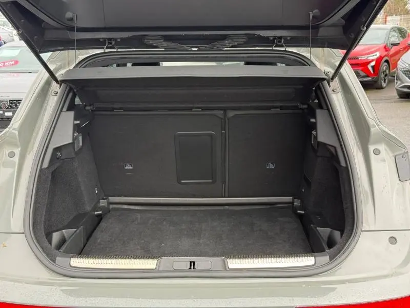Coffre ouvert vu de l'arrière d'un DS7 E-TENSE gris 2024, montrant un espace de chargement propre et spacieux.
