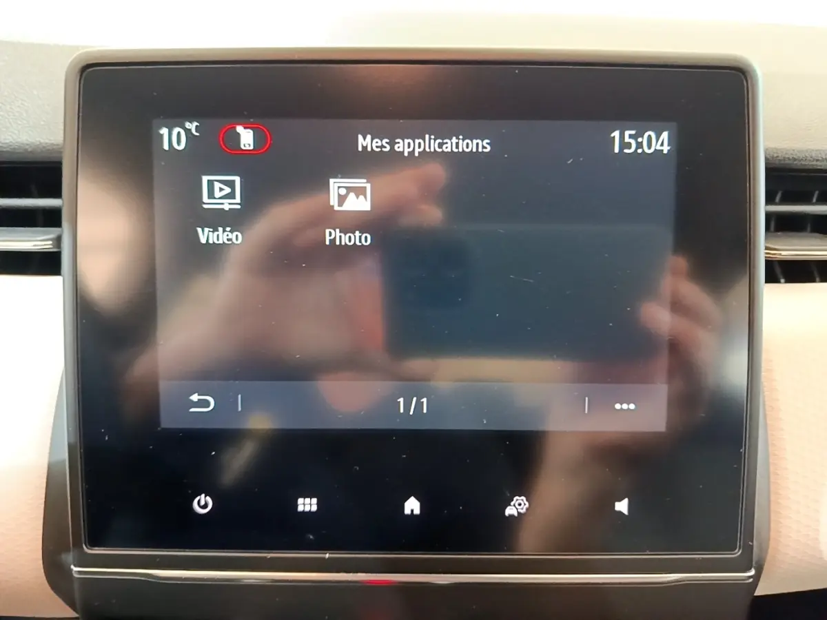 Écran tactile central de la Renault Clio Evolution SCe 65 affichant les applications vidéo et photo, avec interface en français.