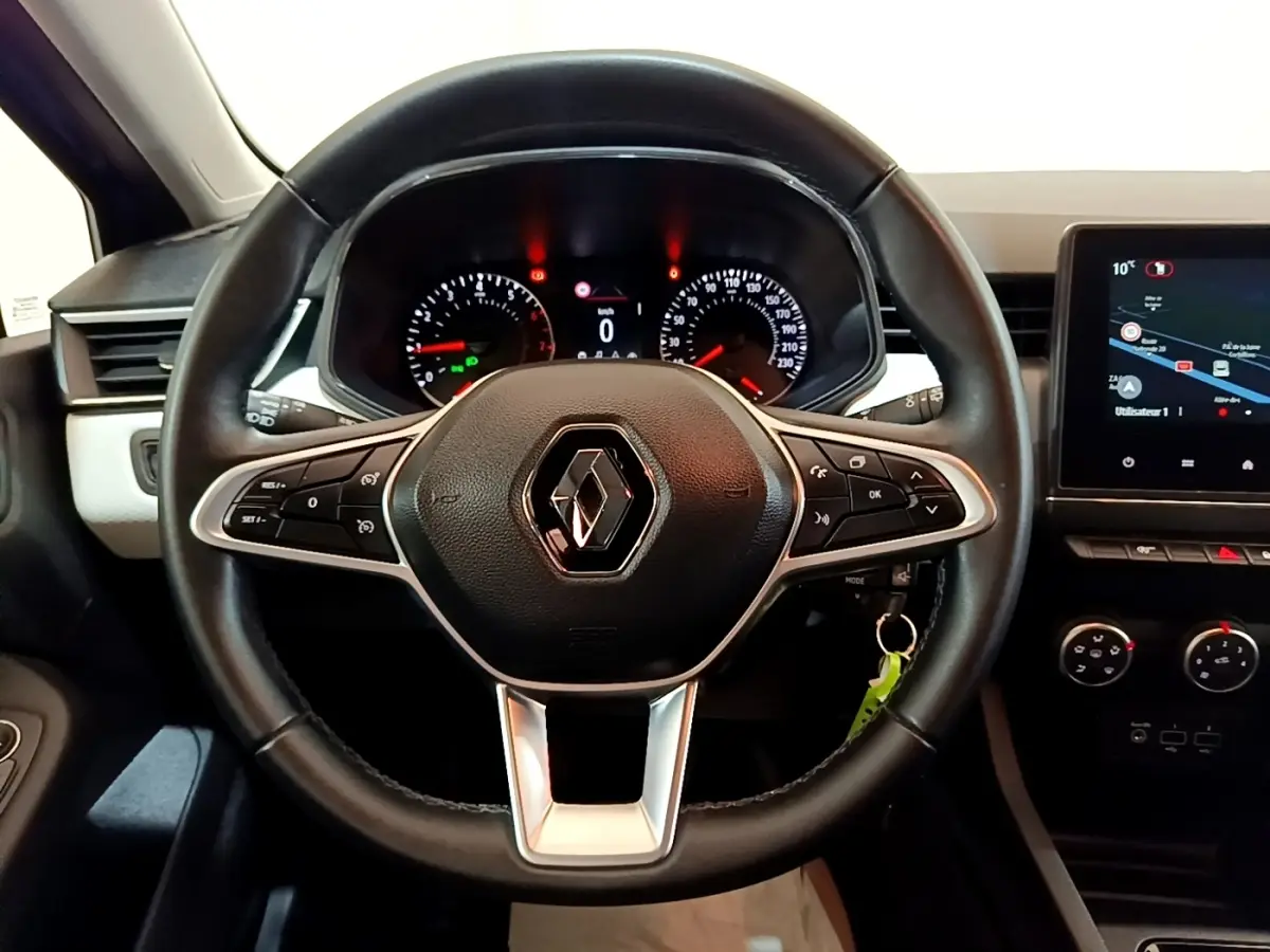 Vue intérieure centrée sur le volant cuir noir de la Renault Clio 2022 avec tableau de bord et écran tactile.
