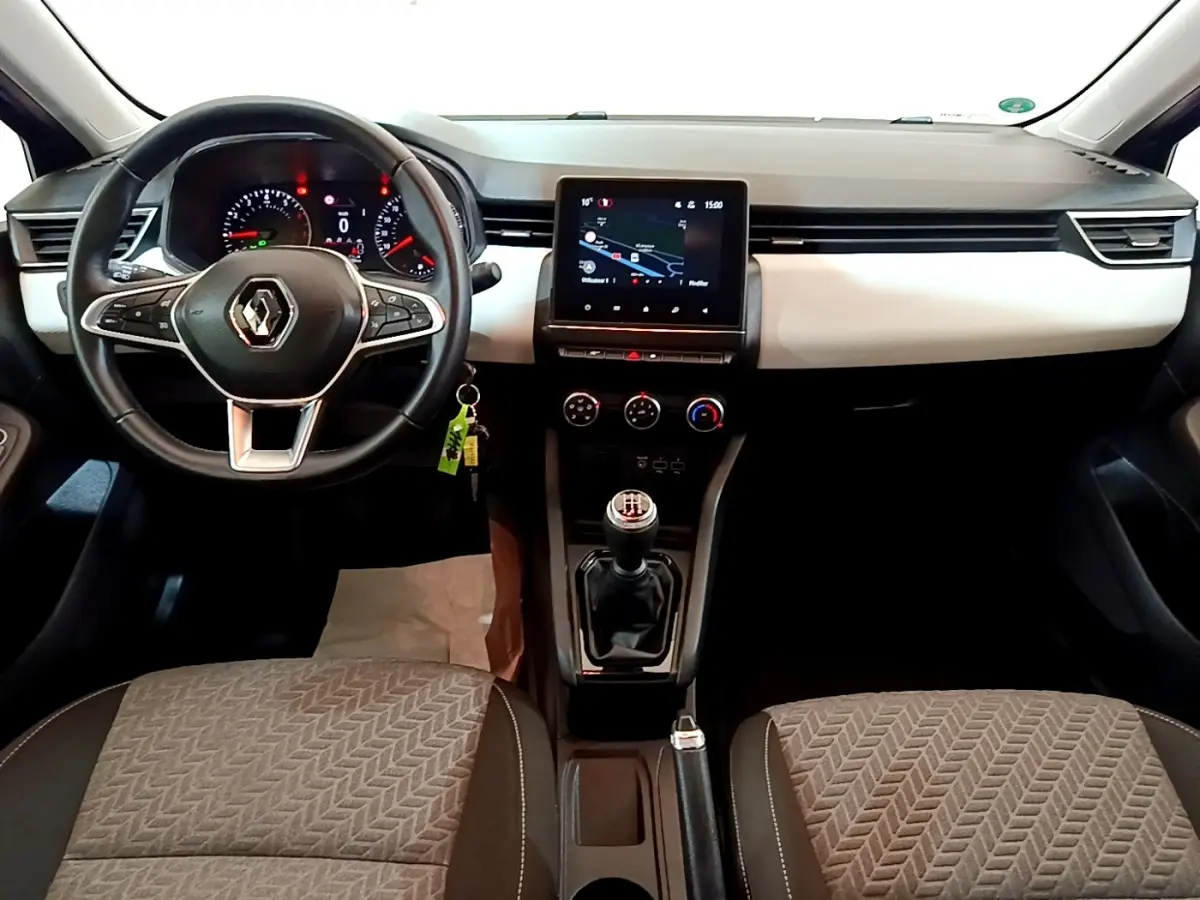 Vue intérieure avant de la Renault Clio bleu, montrant le volant multifonctions en cuir et l’écran tactile central.