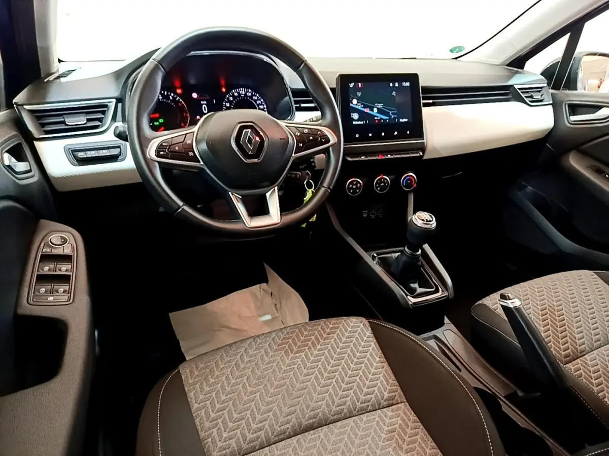 Vue intérieure avant de la Renault Clio Evolution 2022, volant cuir multifonctions et écran tactile de navigation visible.