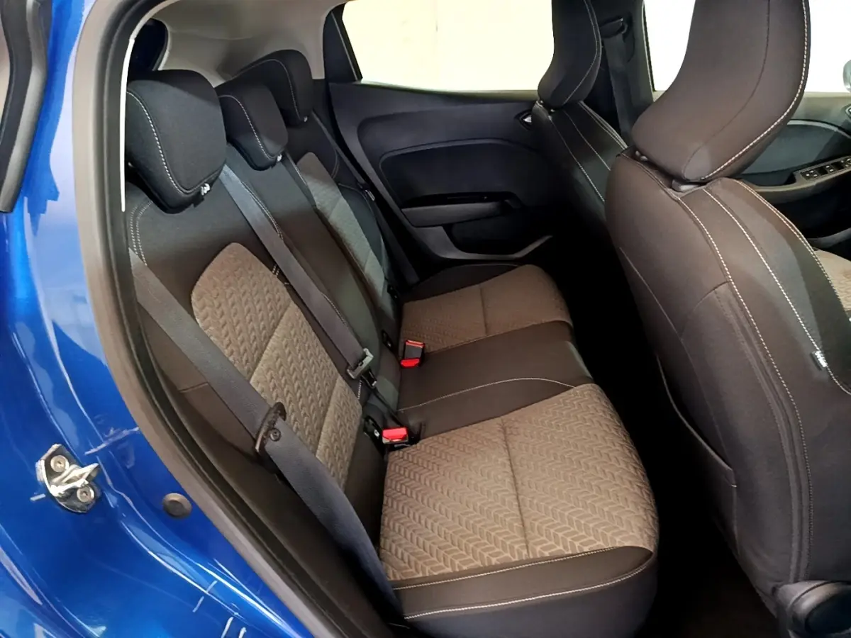 Vue intérieure côté gauche montrant la banquette arrière et la porte bleue d'une Renault Clio Evolution 2022.