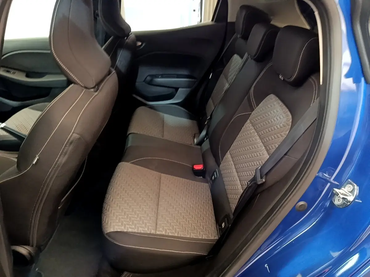 Vue intérieure côté droit sur les sièges arrière en tissu gris et noir de la Renault Clio bleu 2022 avec porte ouverte.