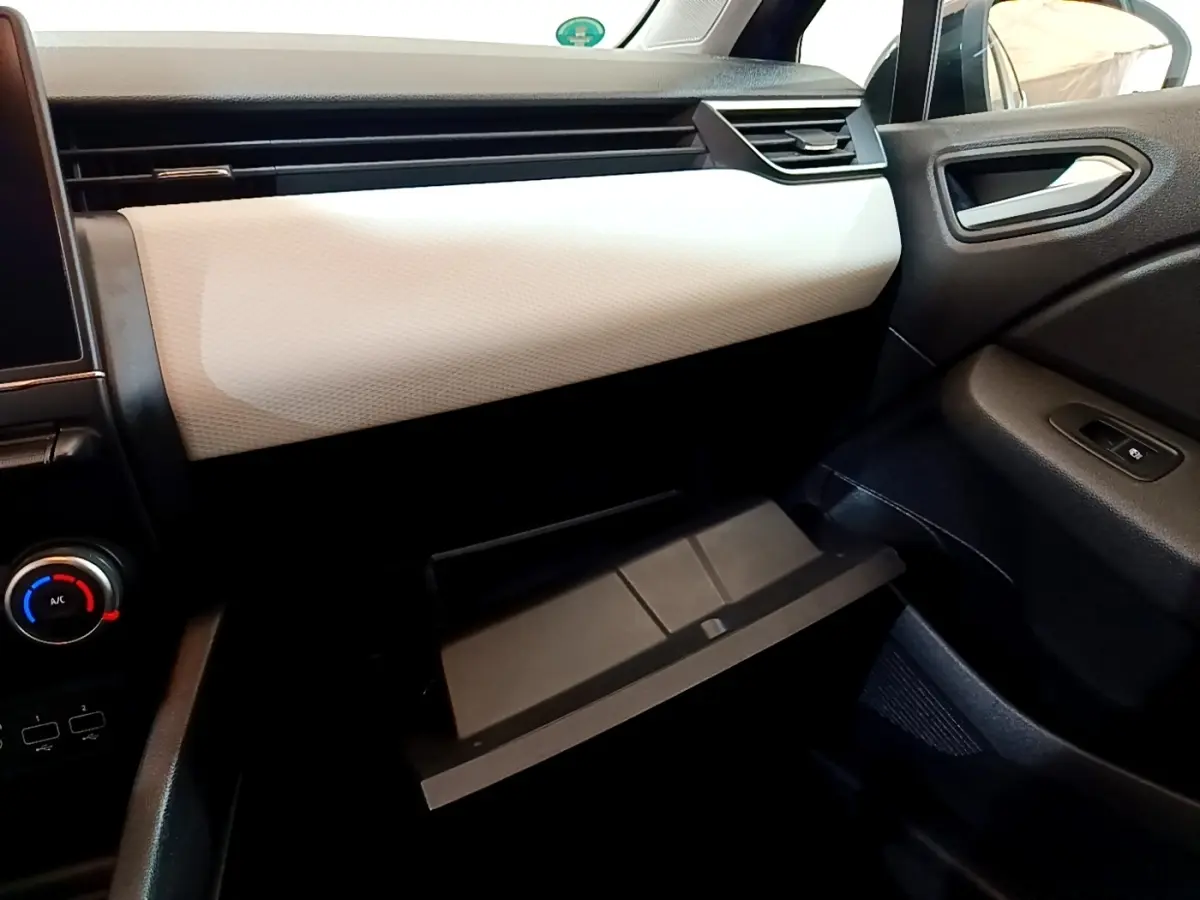 Intérieur de la Renault Clio Evolution SCe 65 2022, vue côté passager avec boîte à gants ouverte et tableau de bord bicolore.