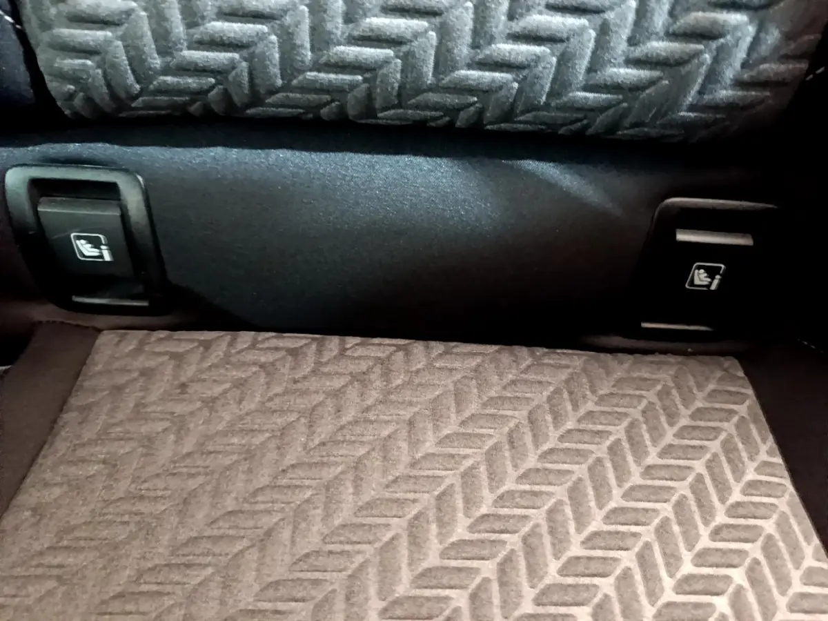 Détail des commandes de rabattement des sièges arrière dans le coffre de la Renault Clio Evolution bleu.