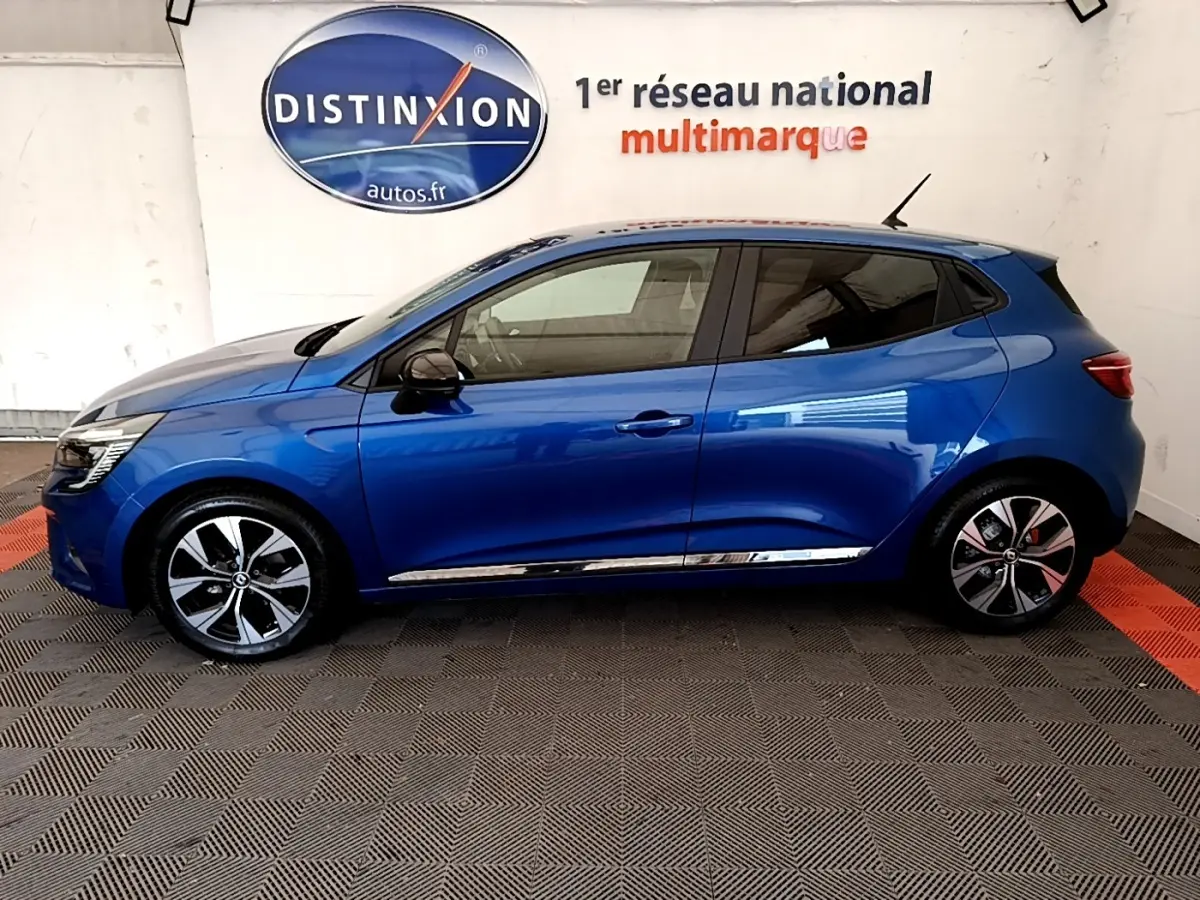Profil droit d'une Renault Clio Evolution bleu 2022 avec jantes alliage et rétroviseurs noirs dans un showroom.