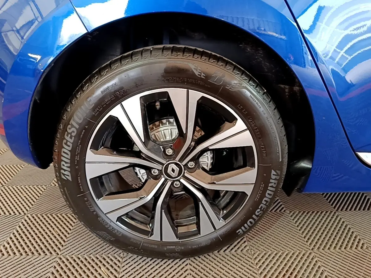 Gros plan sur la roue avant droite de la Renault Clio bleu 2022 avec jante alliage et logo Renault au centre.