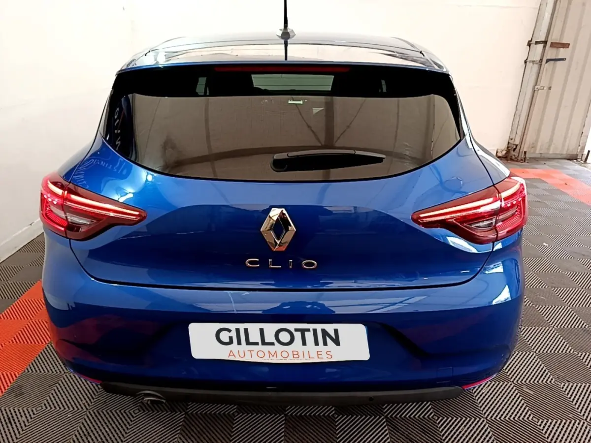 Vue arrière d'une Renault Clio bleu électrique 2022 avec feux LED et lunette arrière teintée.