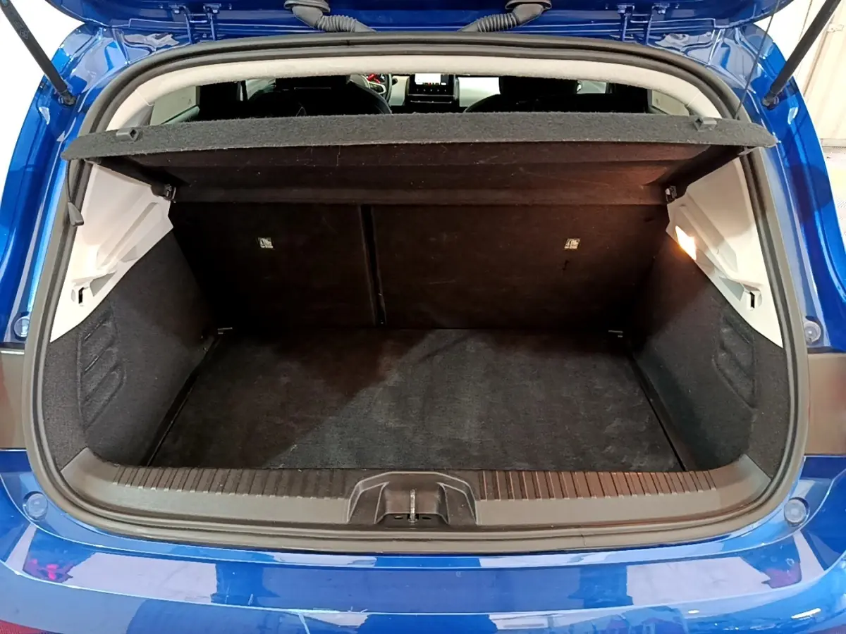 Coffre ouvert vu de l'arrière d'une Renault Clio Evolution bleu 2022, avec tablette cache-bagages relevée.