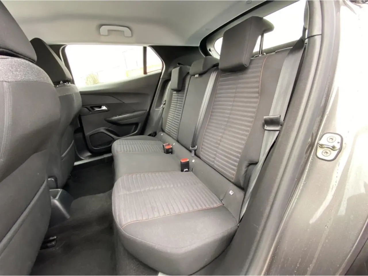 Vue intérieure côté droit montrant la banquette arrière grise avec surpiqûres rouges du Peugeot 2008 2021 Active Pack.