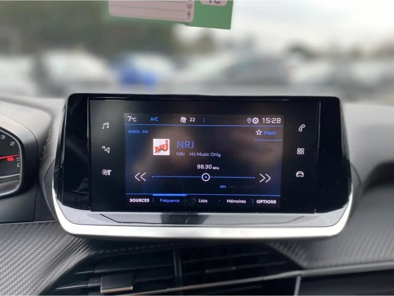 Écran tactile central du Peugeot 2008 2021 affichant la radio NRJ avec commandes tactiles et design moderne.