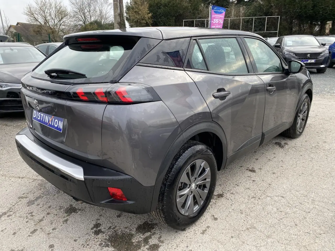 Peugeot 2008 gris foncé en 3/4 arrière droit, avec feux arrière LED 3 griffes et jantes alliage.