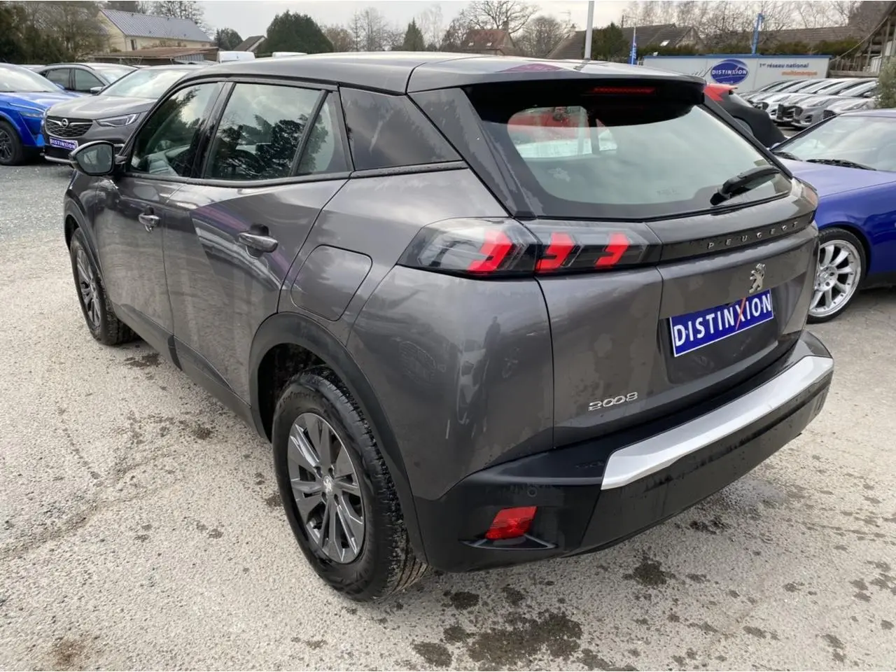 Vue 3/4 arrière droit d’un Peugeot 2008 gris foncé avec feux arrière LED en forme de griffes.