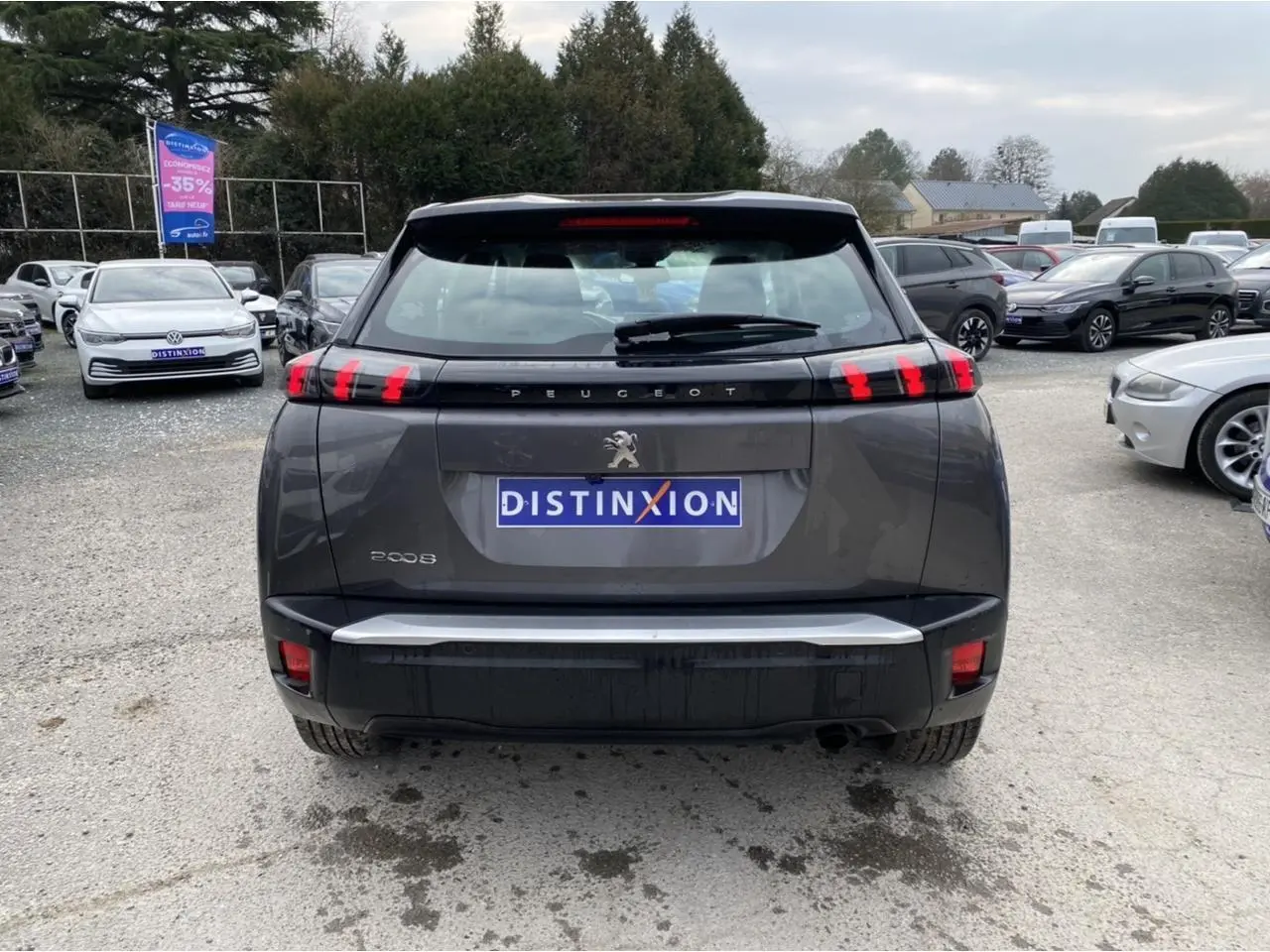 Vue arrière d'un Peugeot 2008 gris foncé avec feux arrière à LED en forme de griffes, sur un parking extérieur.