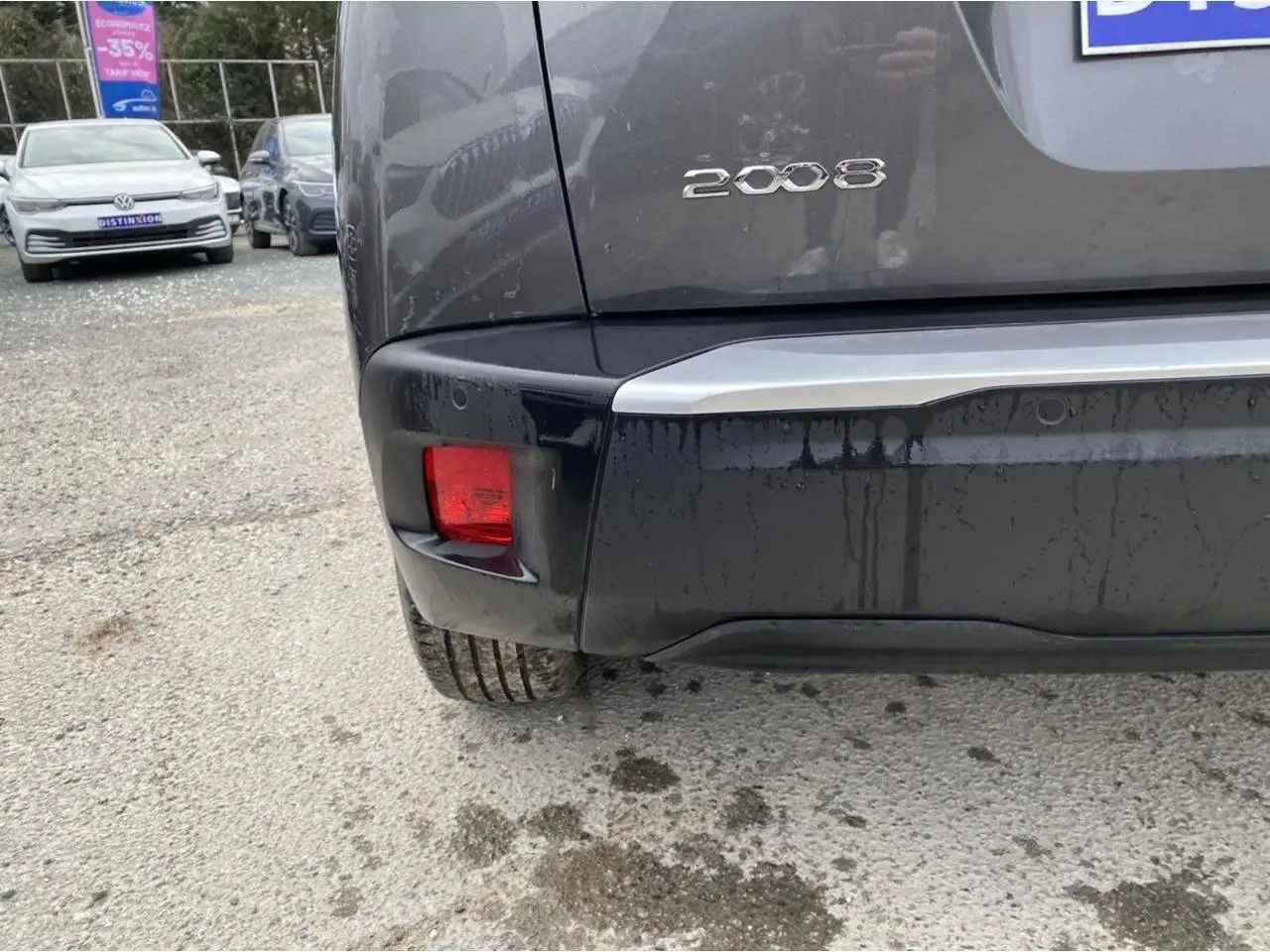 Vue rapprochée du coin arrière gauche d’un Peugeot 2008 gris foncé avec feux arrière et logo visibles.