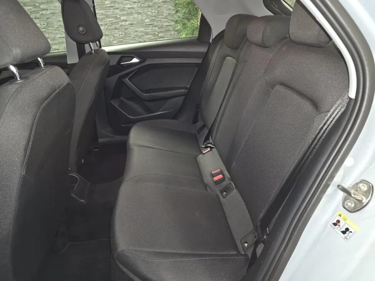 Vue intérieure côté droit des sièges arrière en tissu noir de l'Audi A1 Sportback 2020 avec portières ouvertes.