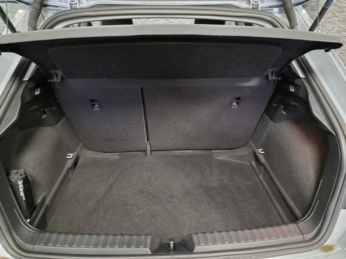 Coffre ouvert vu de l'arrière d'une Audi A1 Sportback gris Manhattan, montrant l'espace de chargement vide et le cache-bagages.