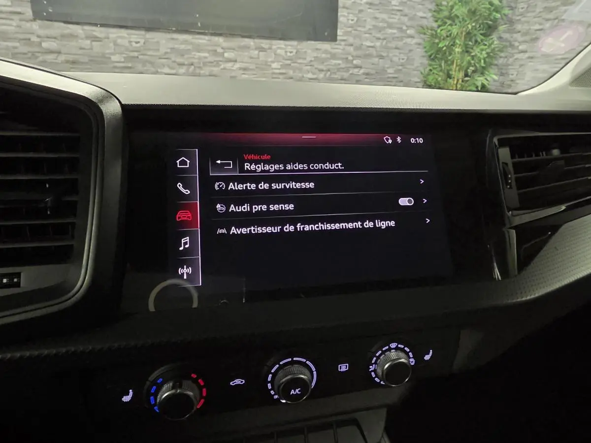 Vue rapprochée de l'écran tactile central et des commandes de climatisation de l'Audi A1 Sportback 2020.