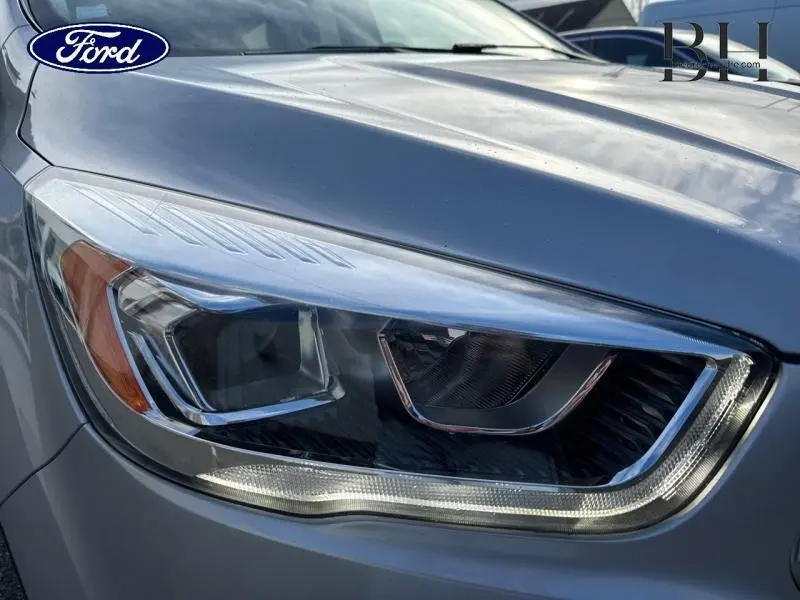 Gros plan sur le phare avant droit du Ford Kuga gris lunaire 2017, soulignant son design moderne et précis.