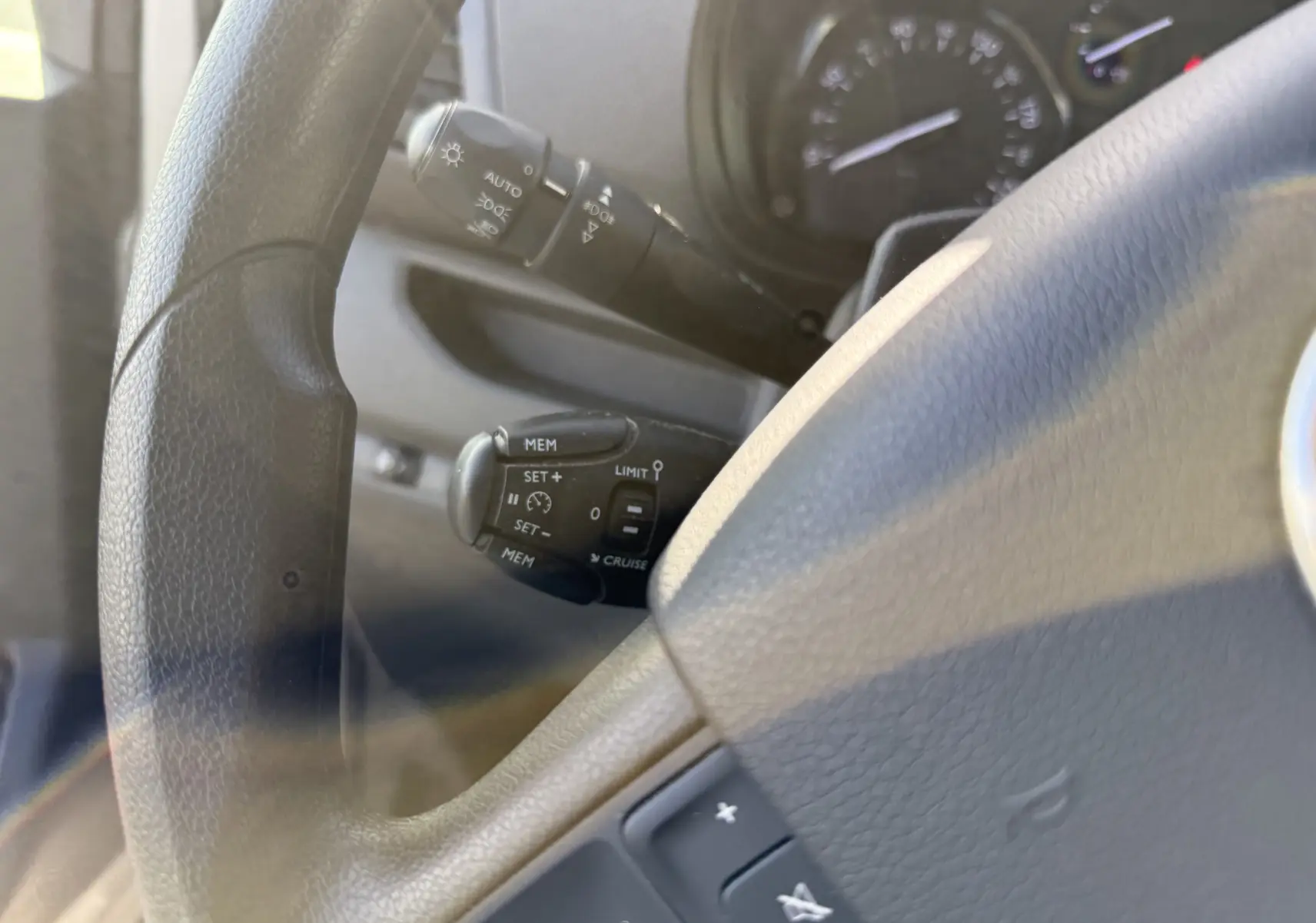 Gros plan sur le volant noir du Fiat Scudo cabine approfondie 2022, avec commandes de régulateur de vitesse visibles à gauche.