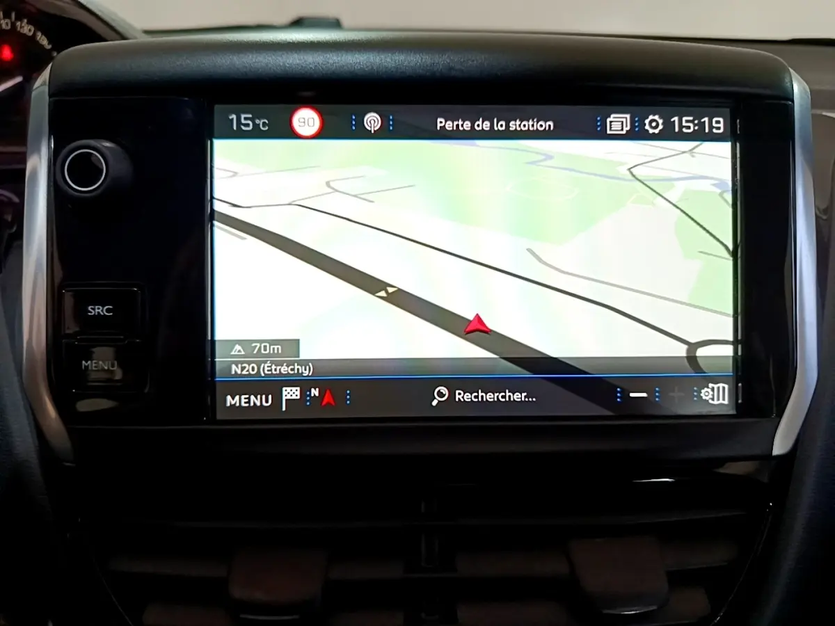 Écran tactile central de navigation 7 pouces de la Peugeot 208 blanche, vue frontale rapprochée du tableau de bord.