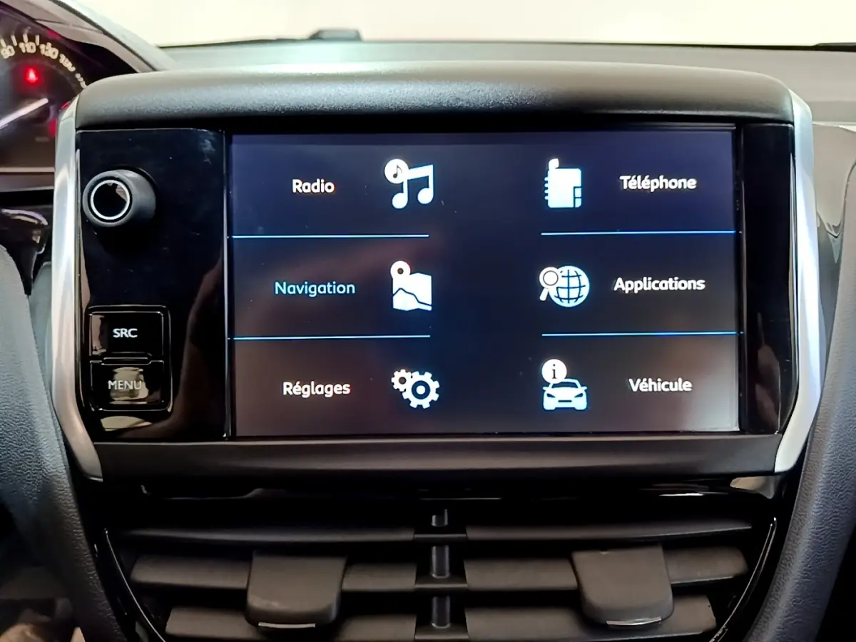 Écran tactile central de la Peugeot 208 Puretech 82 blanc, affichant les options radio, navigation et téléphone.