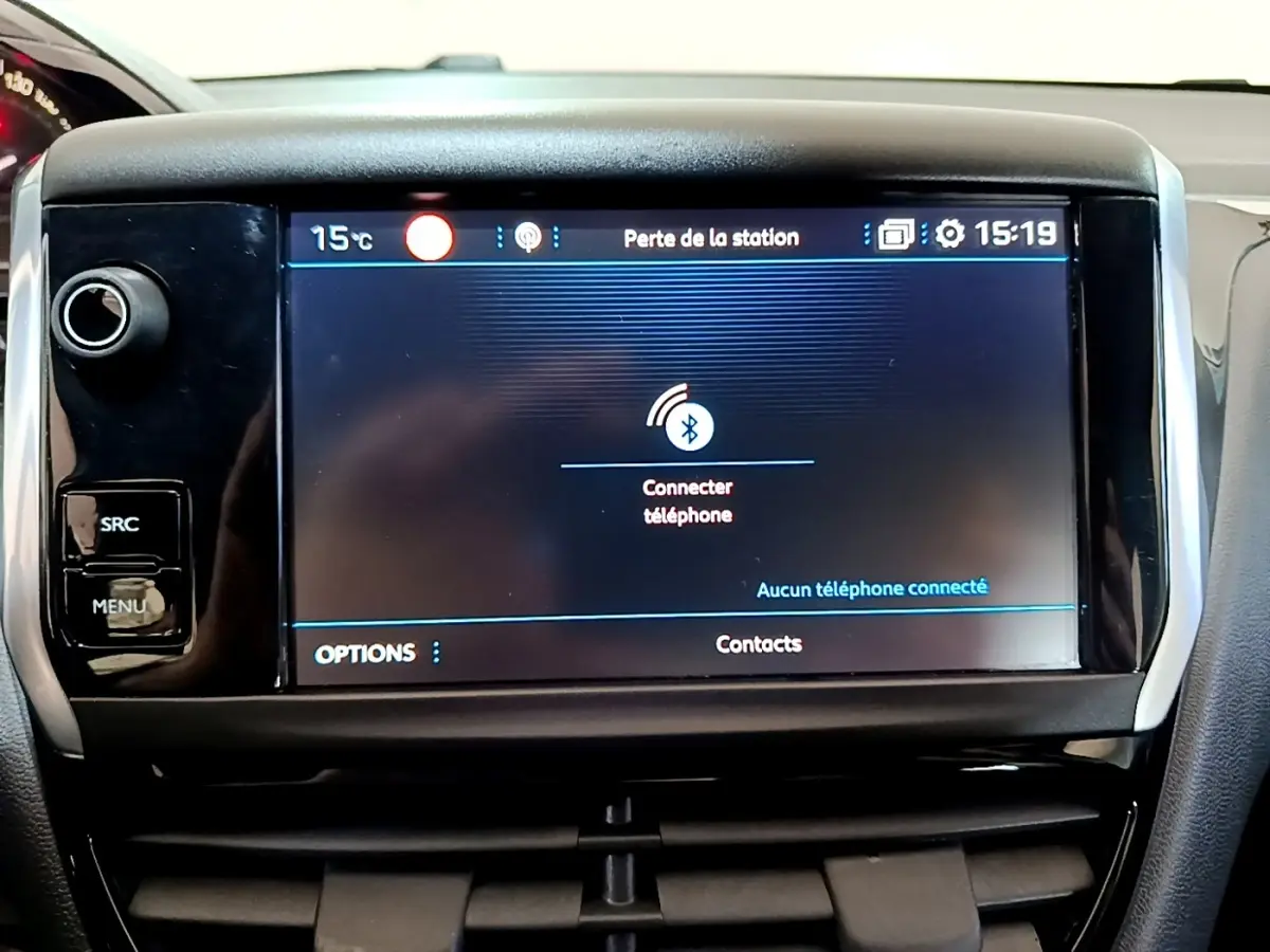 Écran tactile central de la Peugeot 208 Puretech 82 blanc, affichant la connexion Bluetooth téléphone.