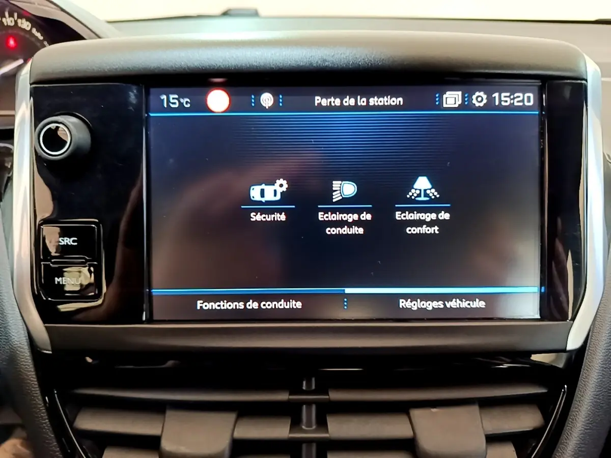 Écran tactile central de la Peugeot 208 Puretech 82 blanc, affichant les réglages de conduite et sécurité.