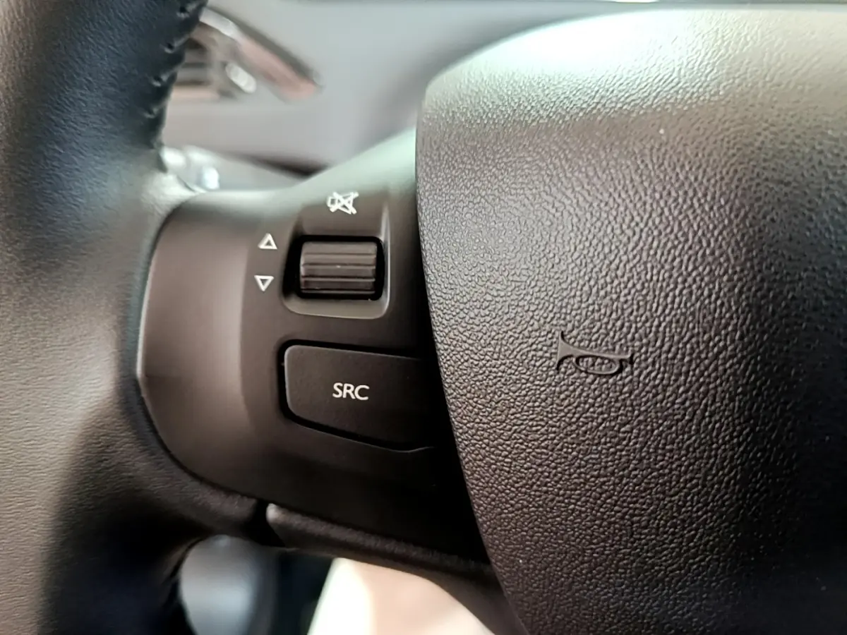 Gros plan sur les commandes audio au volant noir de la Peugeot 208 Puretech 82 S&S Active Business 2018.