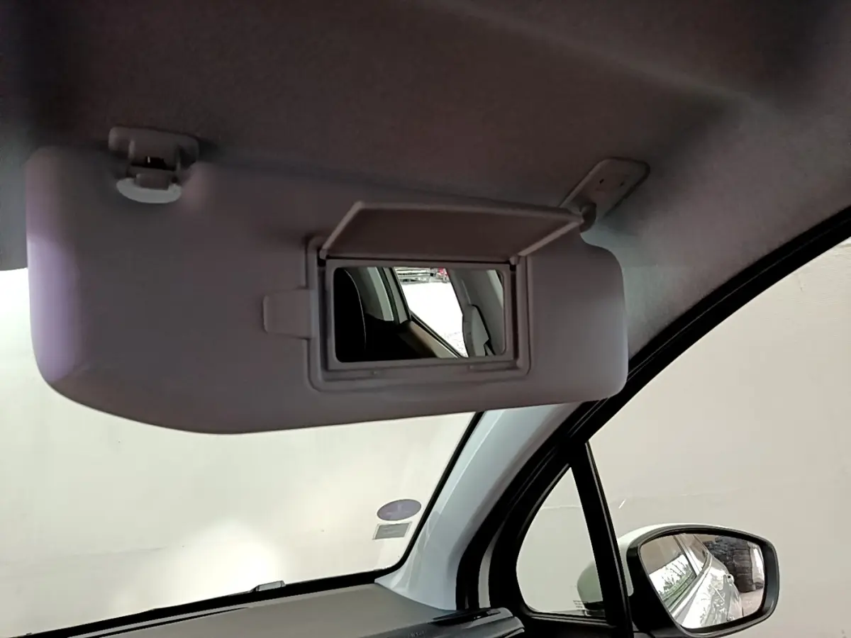 Miroir de courtoisie ouvert sur pare-soleil intérieur côté conducteur d'une Peugeot 208 blanche, vue rapprochée.
