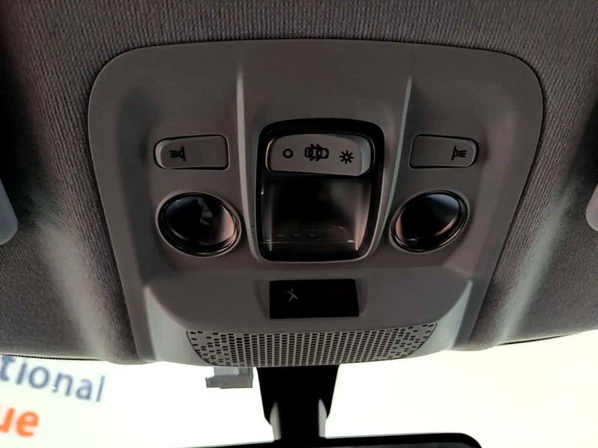 Vue intérieure du plafonnier gris avec commandes d’éclairage et boutons SOS d’une Peugeot 208 blanche 2018.