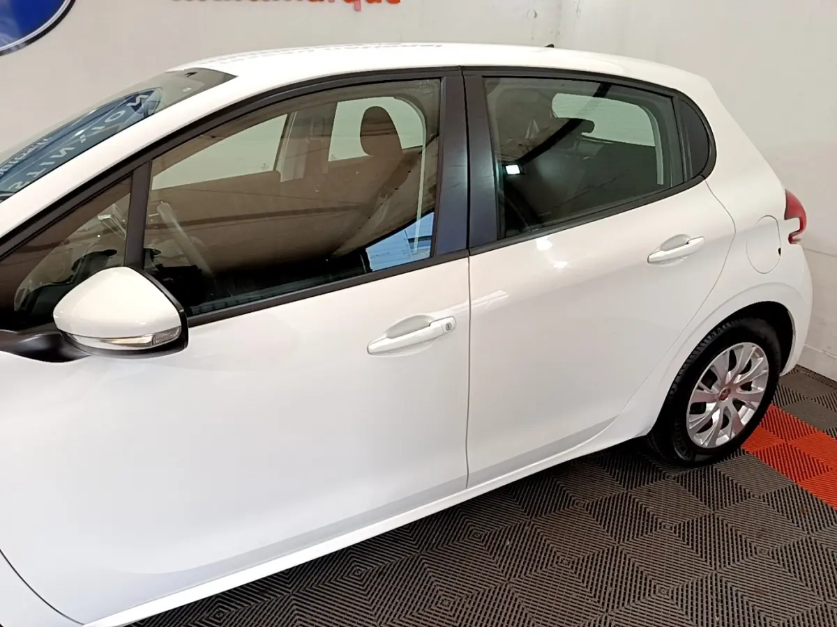 Vue latérale droite d'une Peugeot 208 blanche, mettant en valeur les portes et les rétroviseurs extérieurs.