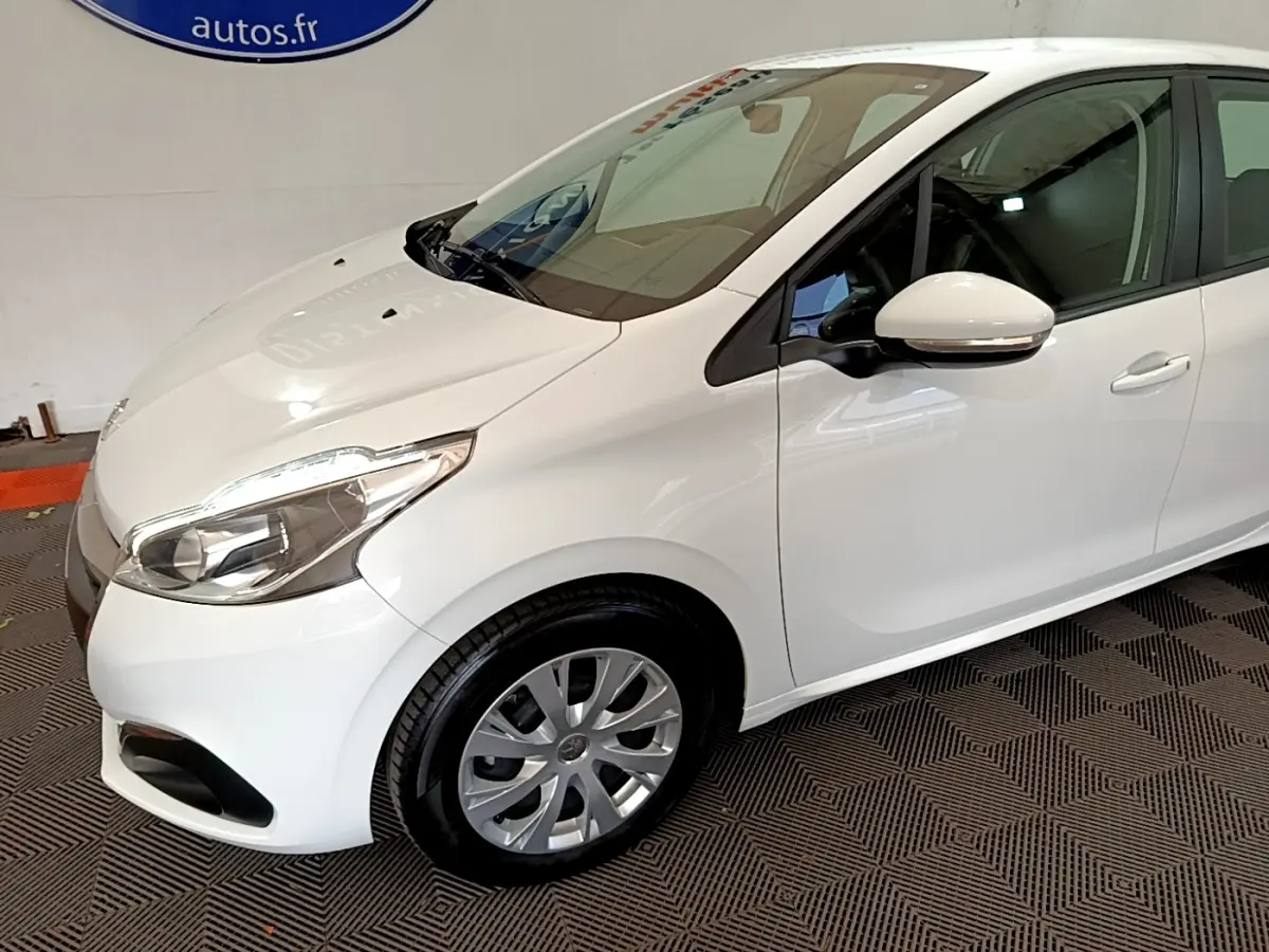 Vue 3/4 avant droit d'une Peugeot 208 blanche avec phares halogènes et rétroviseurs blancs intégrant clignotants.