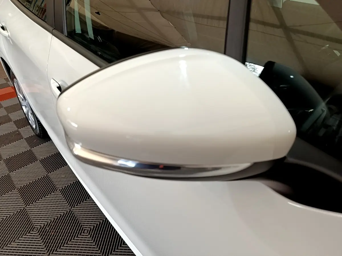 Gros plan sur le rétroviseur droit blanc avec clignotant intégré de la Peugeot 208 blanche, vue côté passager.