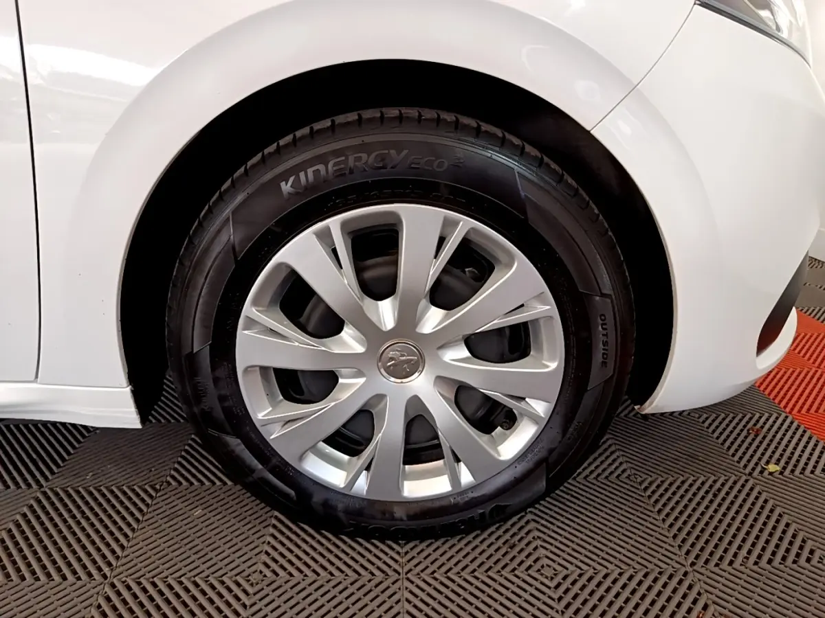 Gros plan sur la roue avant droite d'une Peugeot 208 blanche, avec jante en alliage et pneu Kinergy Eco².