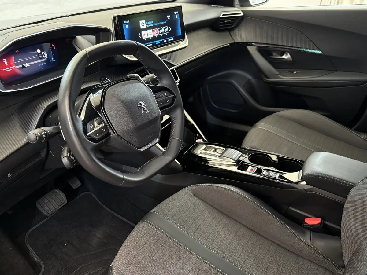 Intérieur de la Peugeot 2008 PureTech 130 gris clair, vue côté conducteur avec tableau de bord digital et écran tactile central.