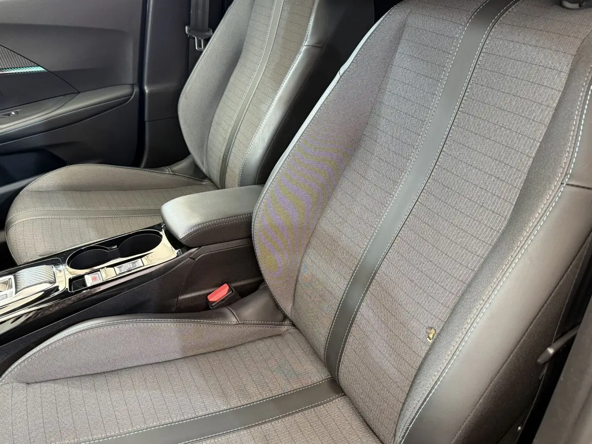 Gros plan sur les sièges avant gris clair en tissu et cuir de la Peugeot 2008 PureTech 130 S&S EAT8 Allure 2023.