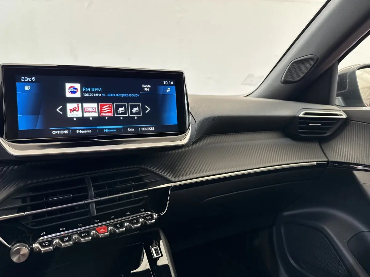 Vue intérieure côté passager du tableau de bord noir avec écran tactile 10 pouces et finitions carbone du Peugeot 2008 gris clair.