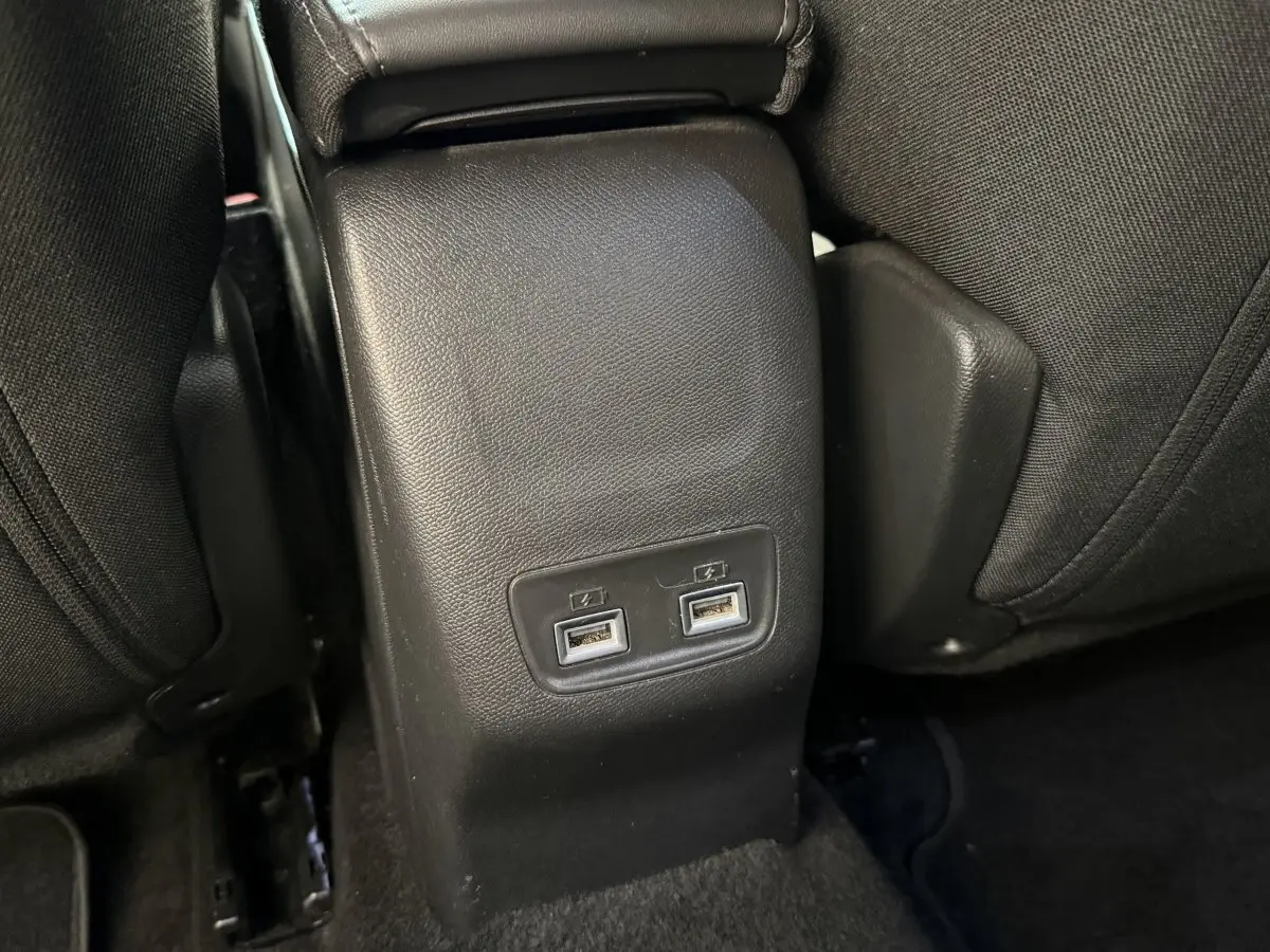 Prise double USB arrière sur console centrale noire entre les sièges arrière du Peugeot 2008 gris clair 2023.