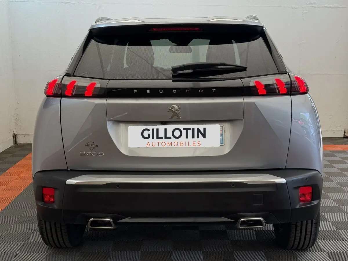 Vue arrière d'un Peugeot 2008 gris clair 2023 avec feux LED caractéristiques et double sortie d'échappement.