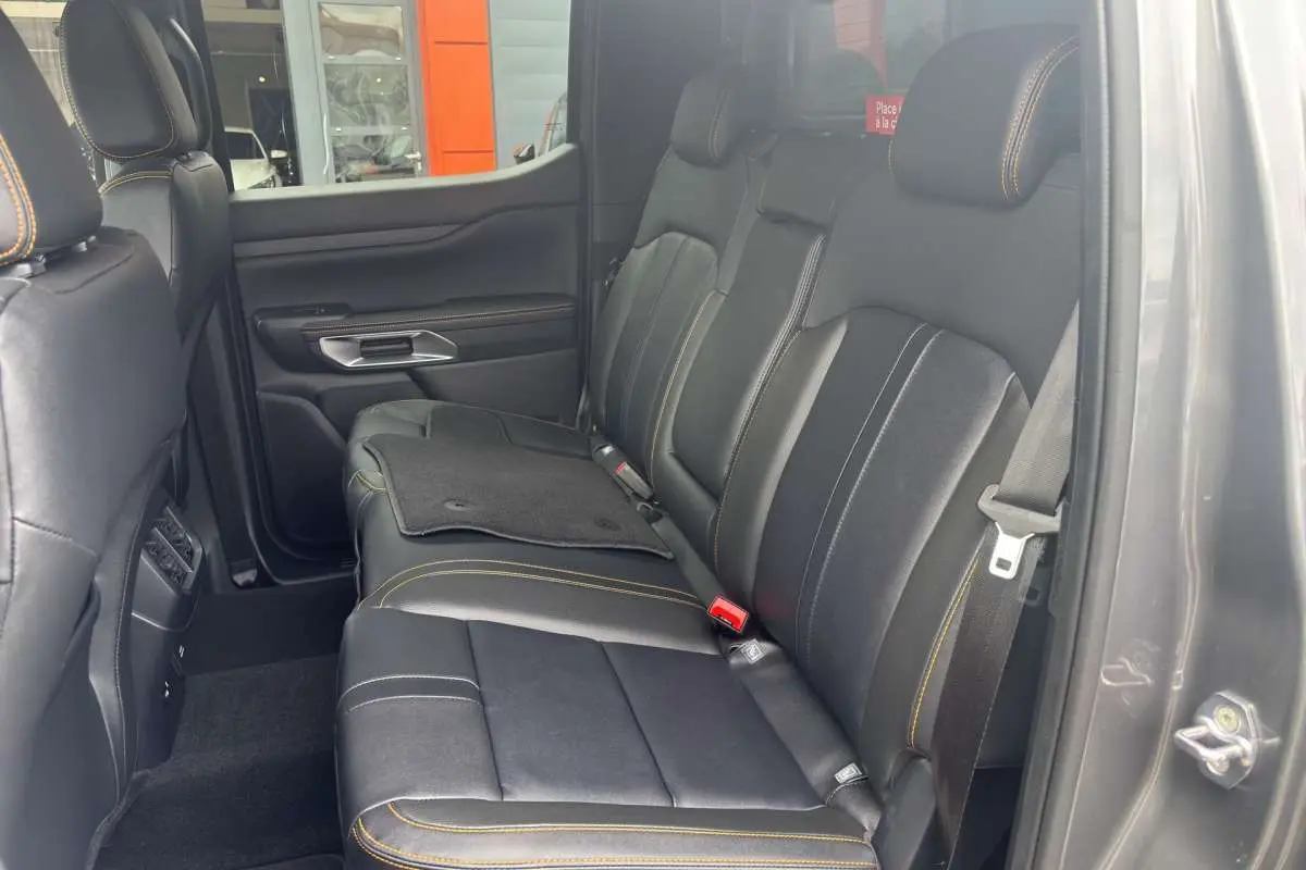 Vue intérieure côté droit des sièges arrière en cuir noir avec surpiqûres jaunes du Ford Ranger Wildtrak 2026 gris carbone.
