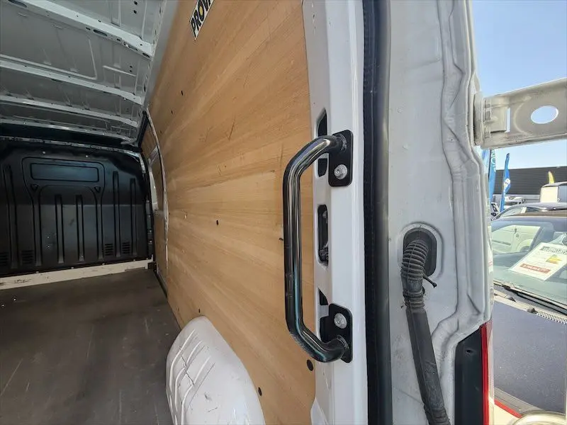 Vue intérieure arrière droite du Renault Master blanc 2021, montrant la paroi boisée et la poignée de porte.