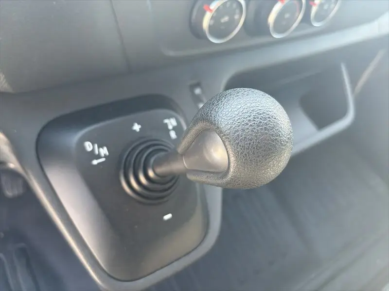 Gros plan sur le levier de vitesses noir de la Renault Master Grand Confort 2021, intérieur sombre.